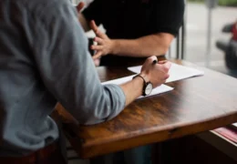 two people discussing at a wooden table who can override a power of attorney form