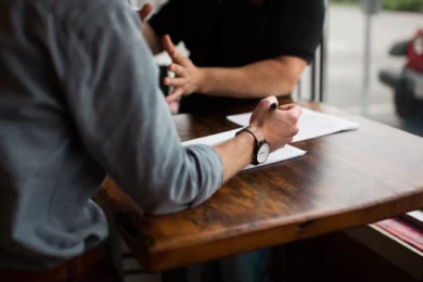 two people discussing at a wooden table who can override a power of attorney form