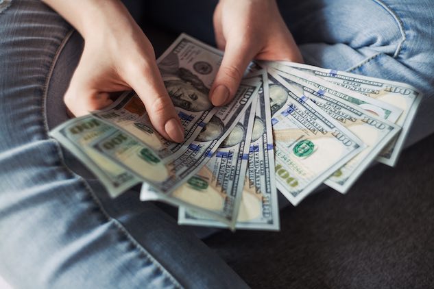 young person fanning one hundred dollar bills after learning what a promissory note is