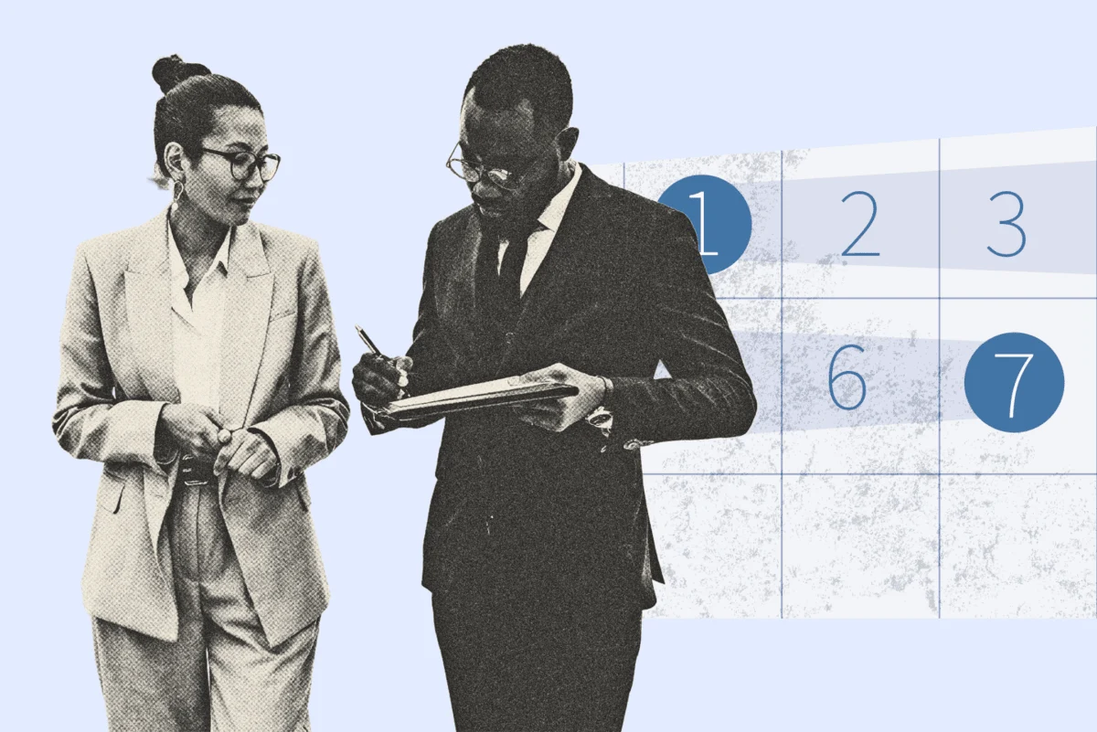 Two professionals reviewing paperwork with a calendar in the background.