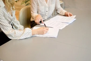 Two employees signing documents