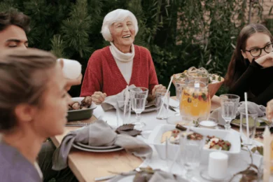 Elderly person at the centre of an outside dinner party