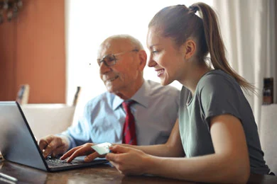 A daughter helps her aging father prepare a power of attorney form